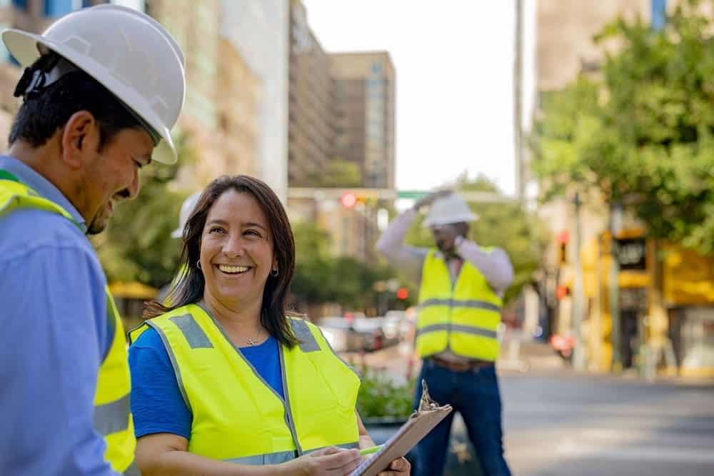 Transit planners discussing project plans on city street.