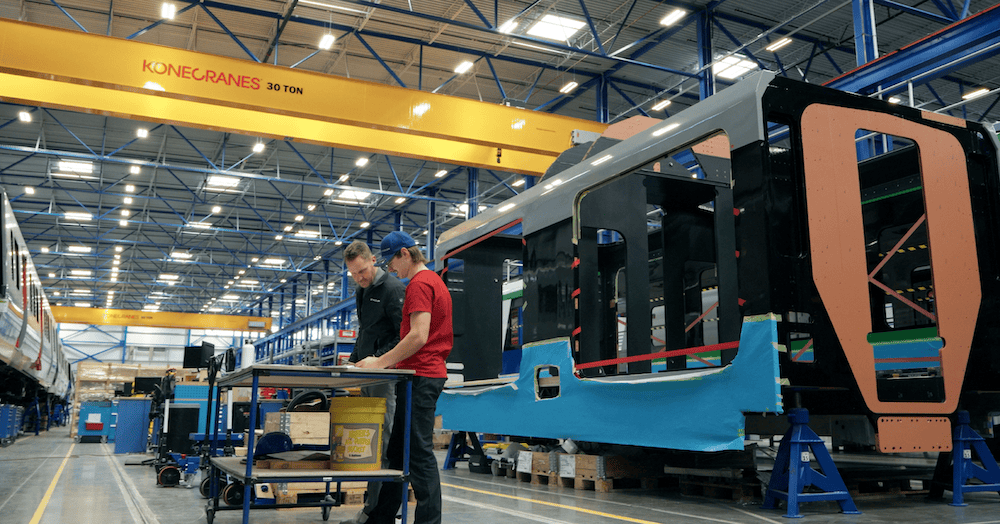 Rail vehicle factory with two workers